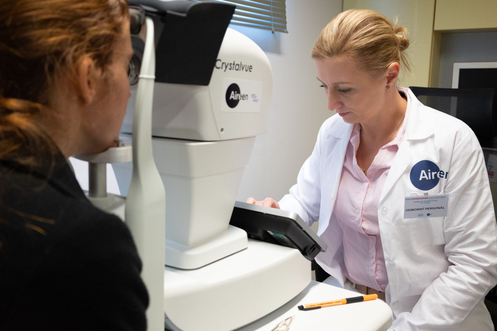 Trained Aireen operator performing a retinal screening on a patient with a tabletop fundus camera